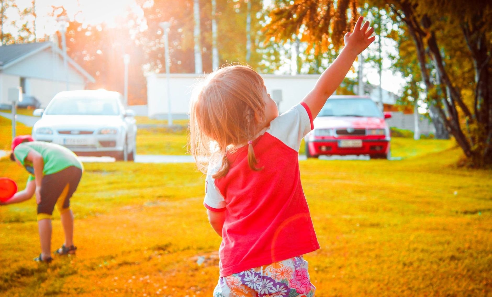Two kids enjoy a sunny day outdoors, playing and exploring in a vibrant, sunny setting.